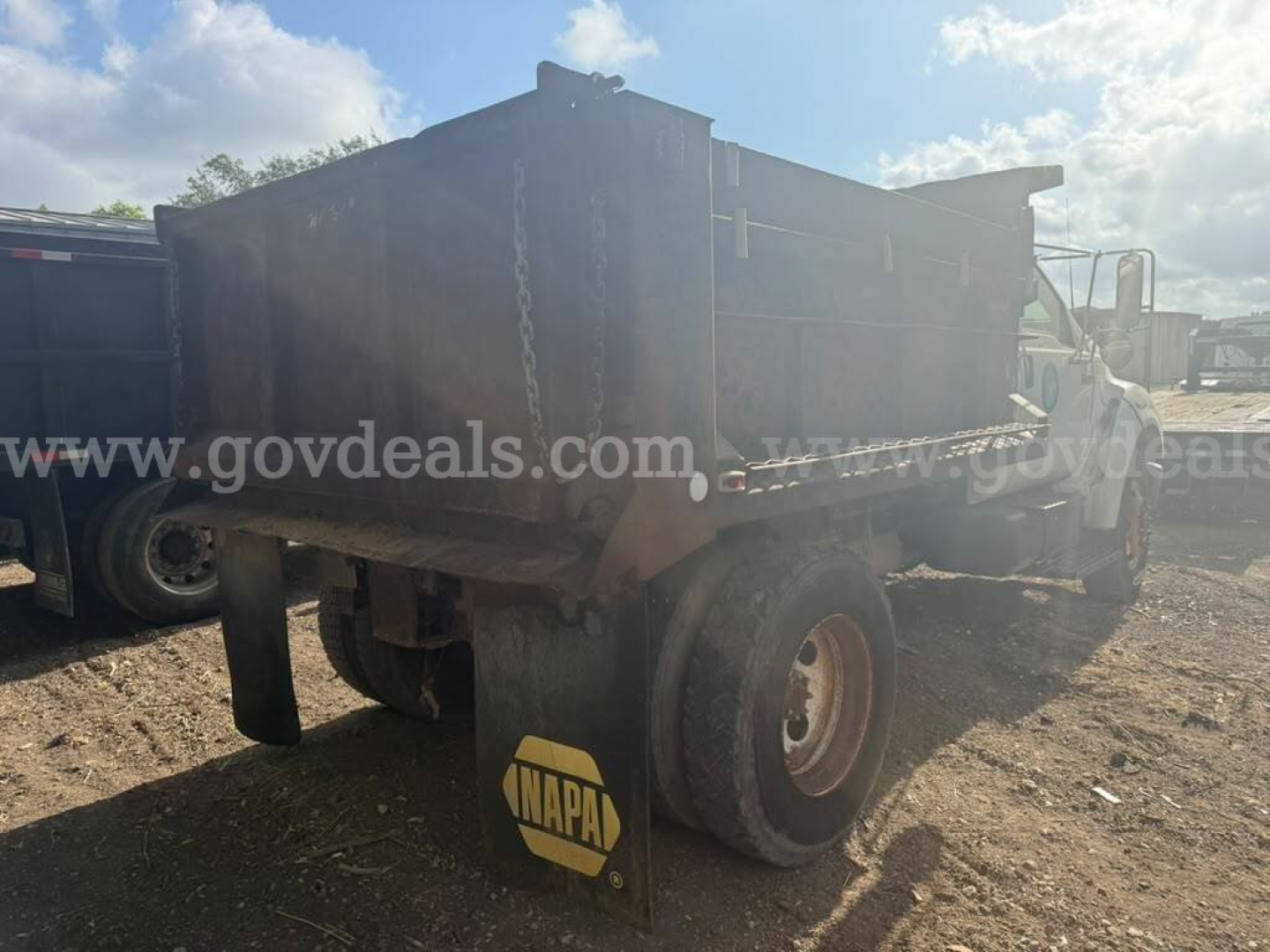 2005 Ford F-750 dump truck in service/utilty category showing dual rear wheels, dump bed, and chain hooks; visible text 'govdeals.com' on side.