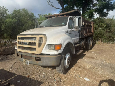 2005 Ford F-750 dump truck in-service view showing front grille, bumper, hood, cab with number 678, and dumped bed at a dusty lot.