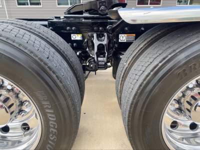 Peterbilt truck chassis and dual rear axles with Bridgestone tires, suspension hitch components visible between wheels.