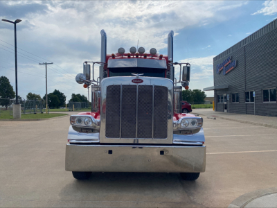 Peterbilt 389 front view showing large chrome grille, dual vertical exhaust stacks, and prominent bumper. Text on the grille reads Peterbilt emblem; no other legible labels visible.