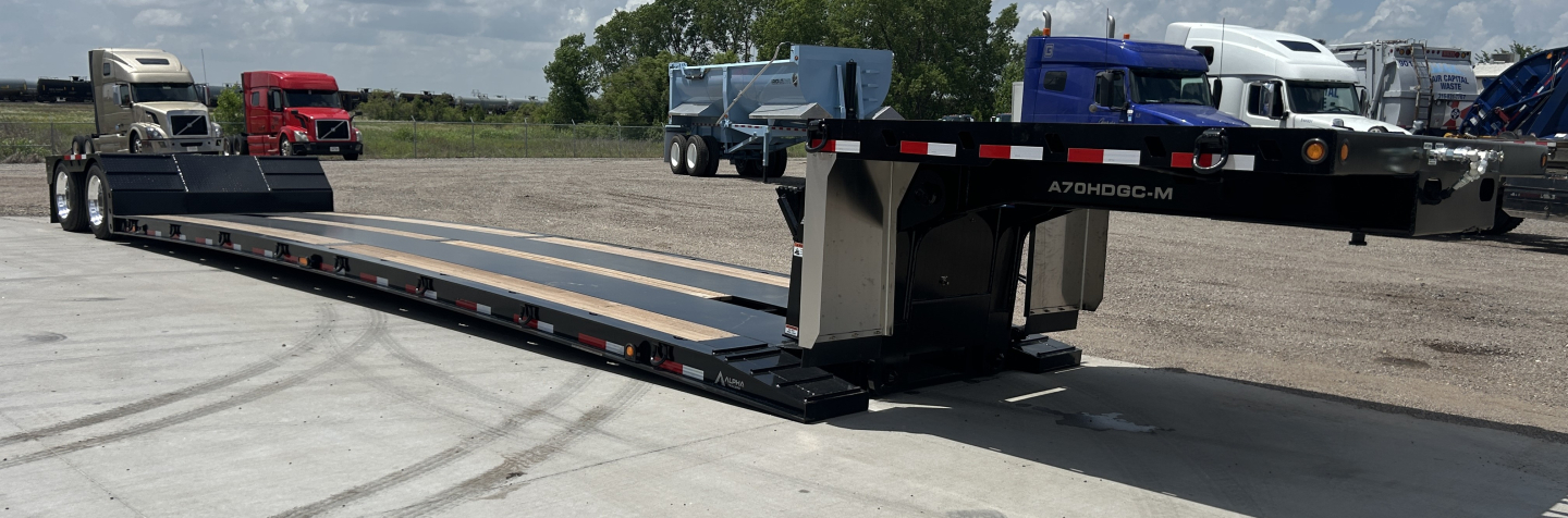 Alpha A70HDGC-M hydraulic detachable double drop mini deck lowboy trailer parked on lot with other trailers in background; hydraulic detatch visible; ramp and deck details