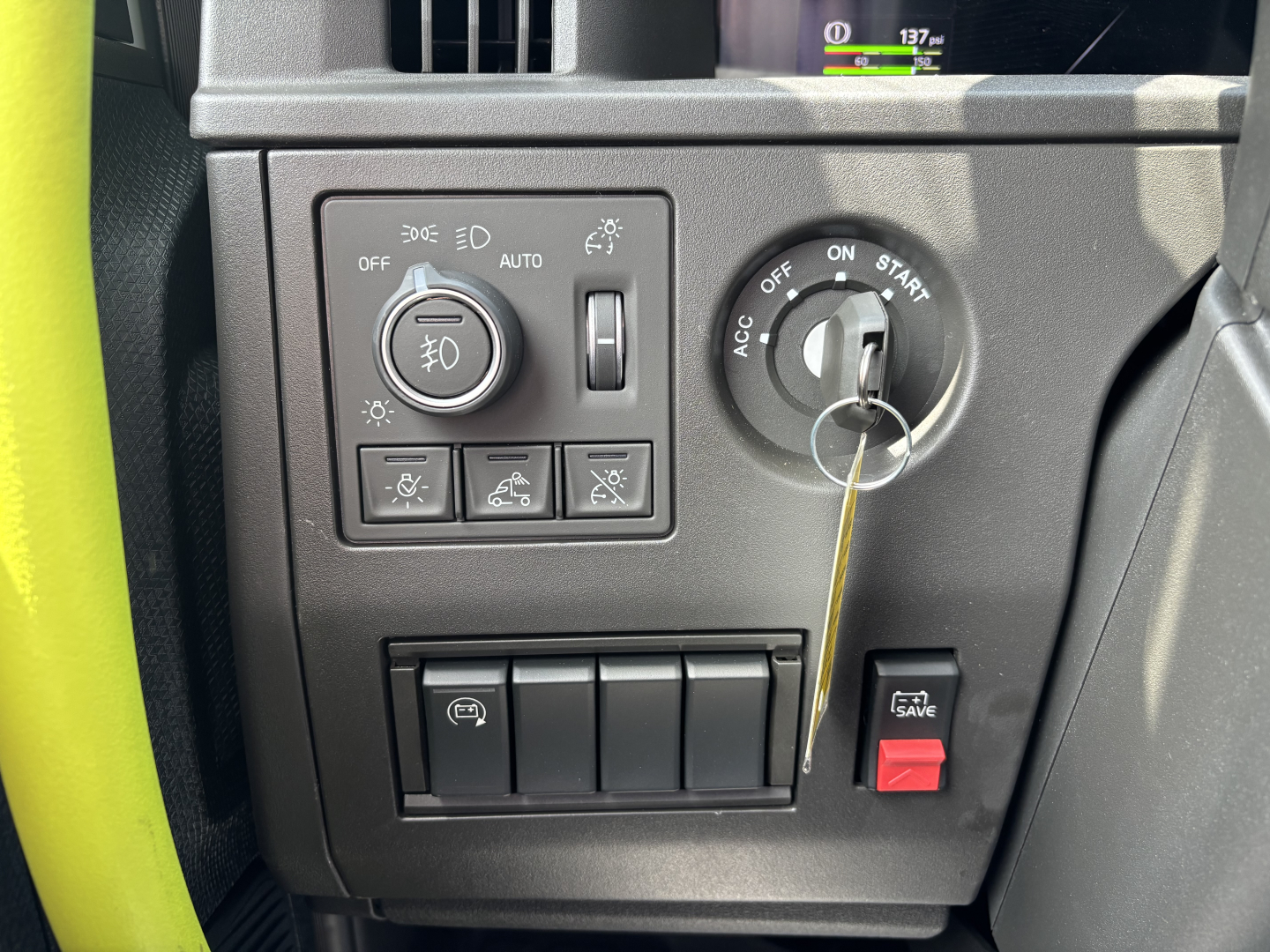 Truck dash area showing headlight control panel and ignition key in Volvo VNL interior.