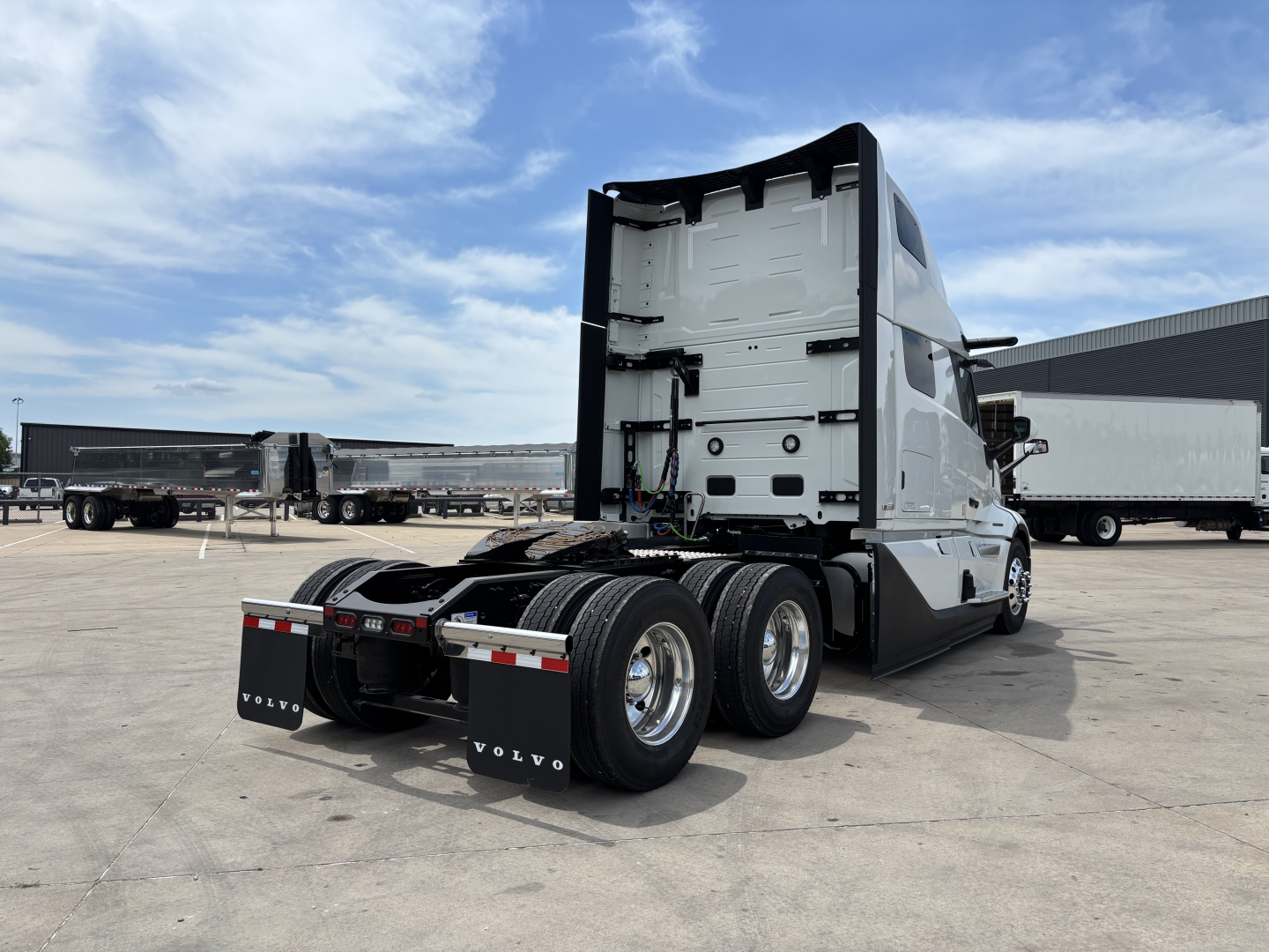 Volvo VNL64T860 tractor rear view showing sleeper cab, rear wheels, and fifth wheel with mud flaps.