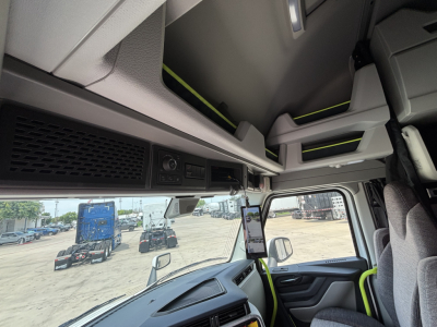 Volvo VNL cab interior view showing dashboard, overhead storage compartments, and a mounted device screen.