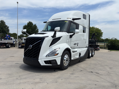 Volvo VNL64T860 truck in white, front-left view showing cab and sleeper with large grille and dual rear axles.