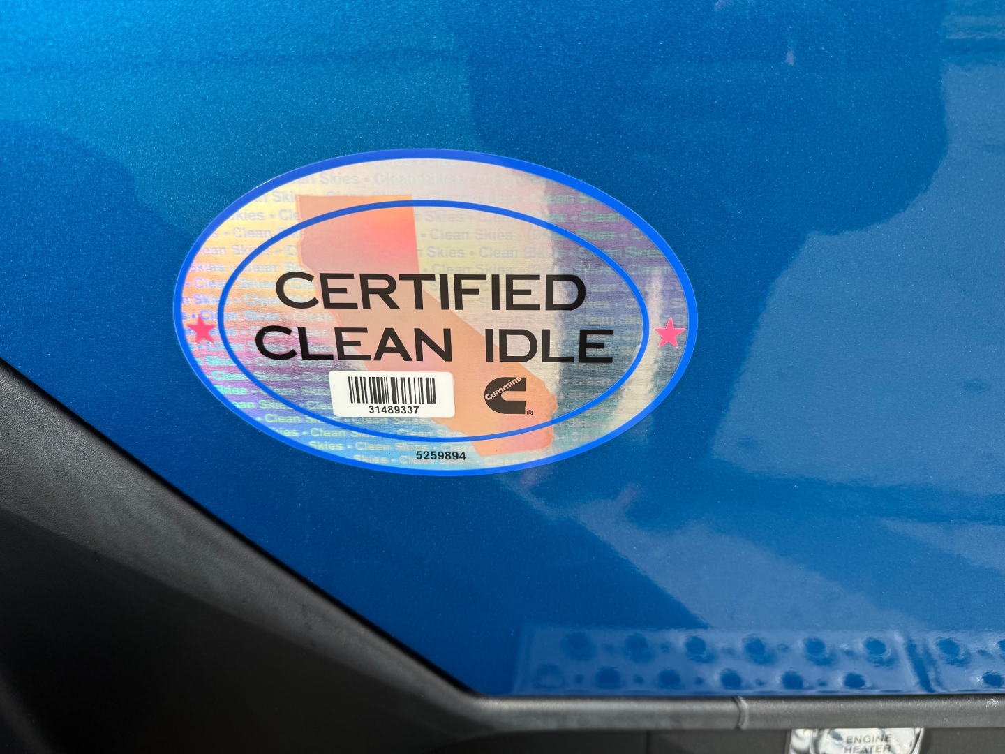Certified Clean Idle sticker on blue Kenworth T680 cab with part of door area visible.