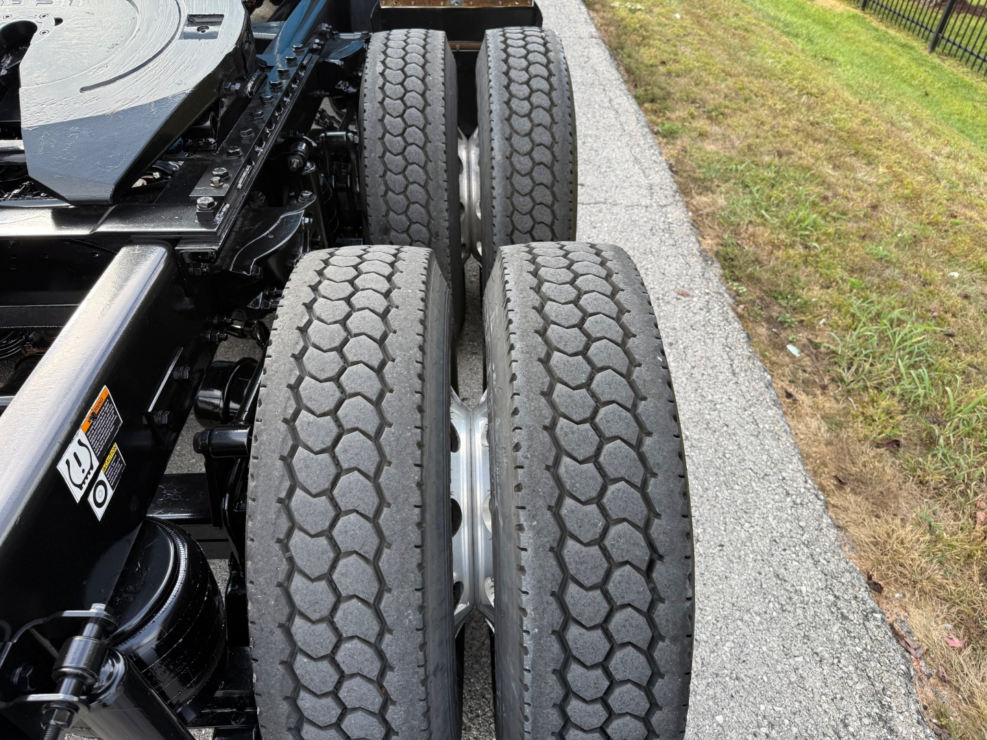 Kenworth T680 wheel detail showing dual rear axles with treaded truck tires.