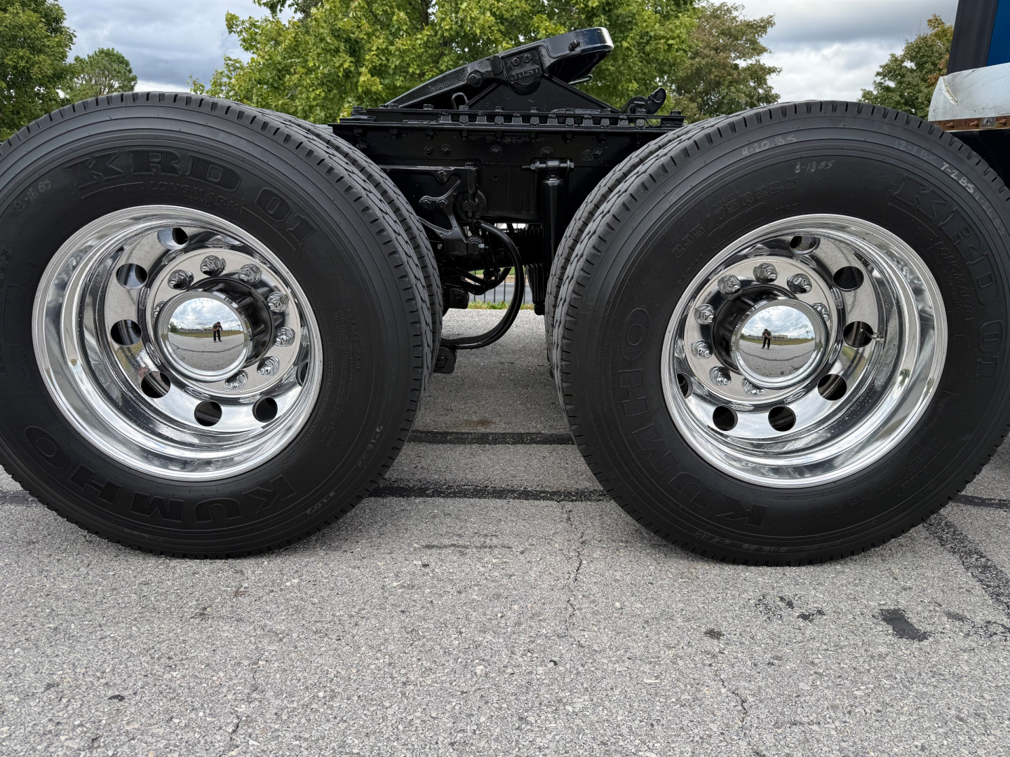 Kenworth T680 wheel pair showing dual rear axles and chrome hubcaps with tire tread details.