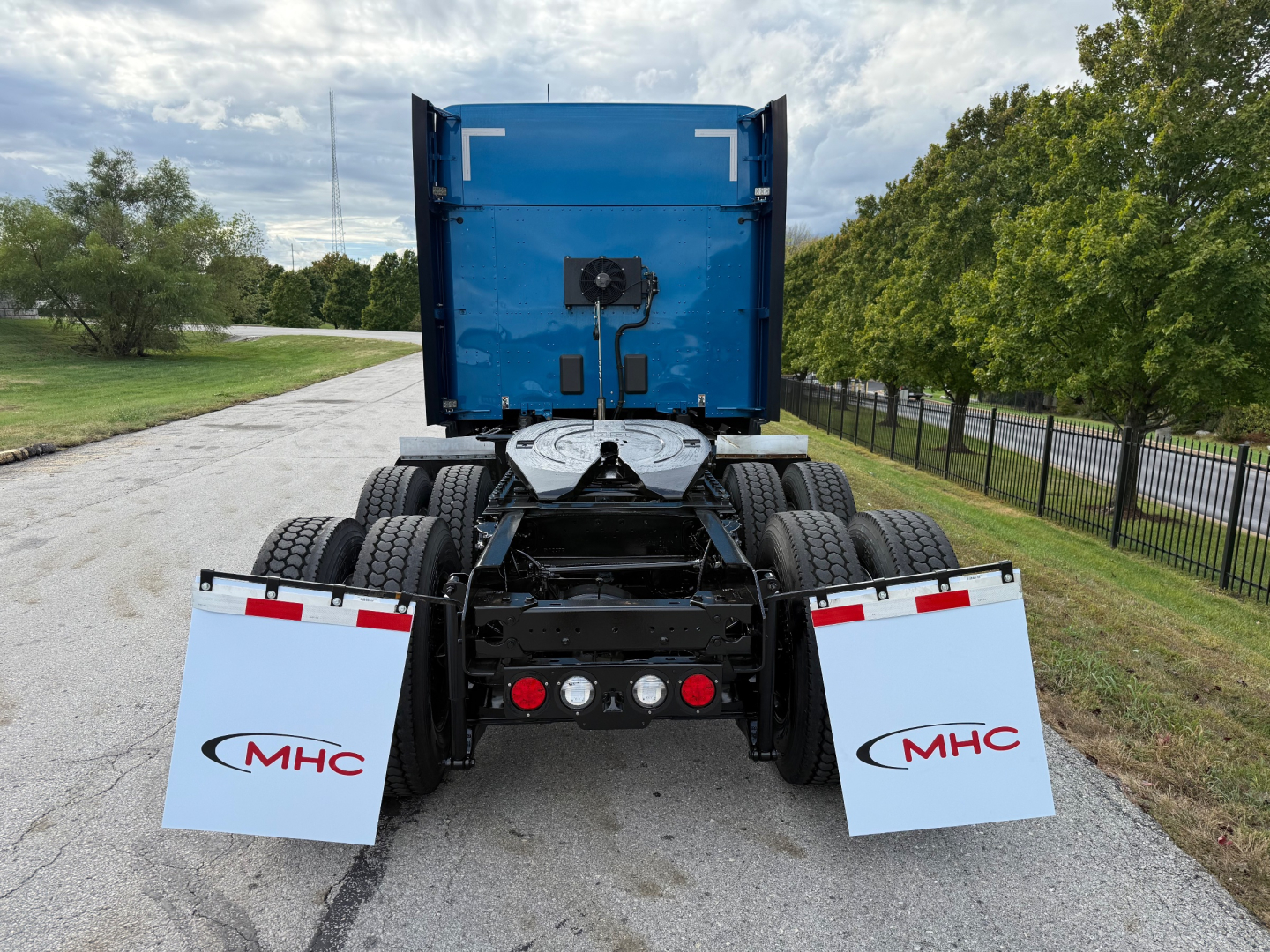Kenworth T680 rear view showing dual rear wheel assembly and MHC mud flaps.