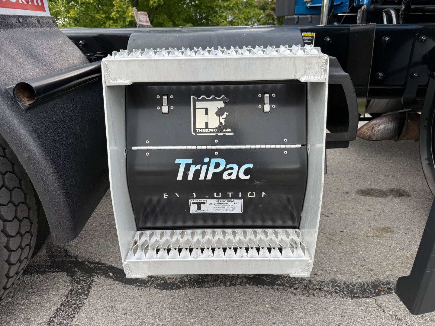 Kenworth T680 auxiliary power unit or battery/aux container with TriPac Evolution label and grille panels visible.