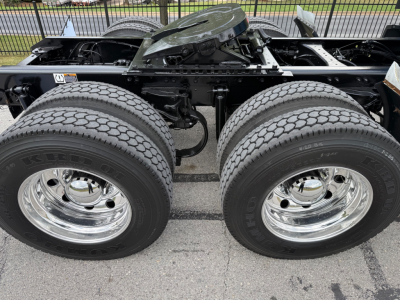Kenworth T680 chassis showing dual rear wheels and suspension components with chrome rims and tires.