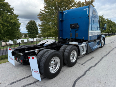 Kenworth T680 tractor rear-side view showing dual rear axles and blue sleeper cab.