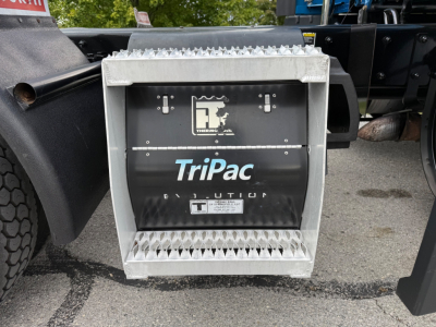 Kenworth T680 auxiliary power unit or battery/aux container with TriPac Evolution label and grille panels visible.