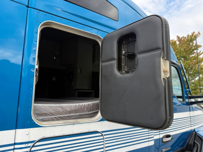 Kenworth T680 truck sleeper cab exterior with open door showing interior cabin area and blue paint.