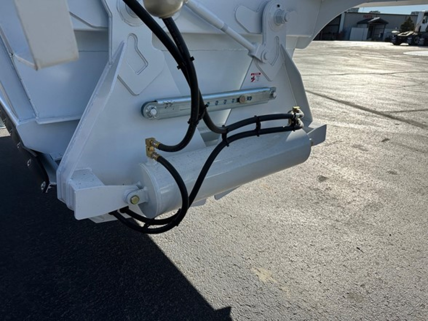 CPS air ride bottom dump trailer hitch area showing hydraulic lines and frame component with hoses and fittings.