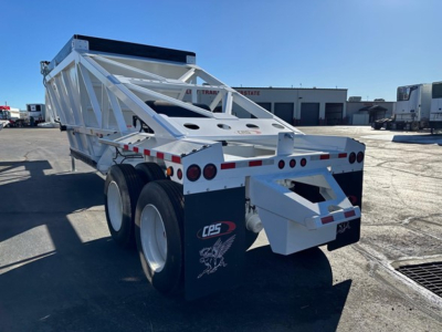 CPS air ride bottom dump trailer showing white frame, dual rear axles, and rear ramp with CPS logo and safety lights.