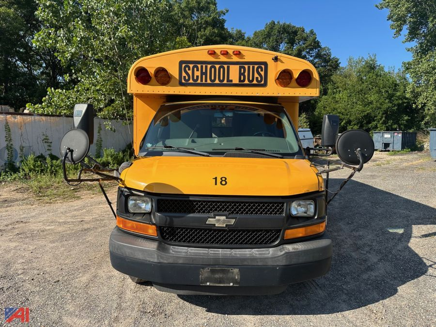 School bus front view showing Chevrolet Express G4500 with wheelchair lift equipment and school bus sign on the roof.