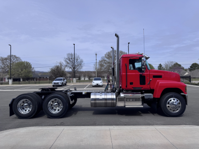 Side view of a 2027 Mack PI64T conventional daycab truck showing the cab, fuel tanks, exhaust stack, and chassis.