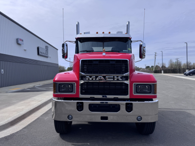 Front view of a red 2027 Mack PI64T conventional daycab truck with large black grille, chrome bumper, and dual vertical exhaust stacks.