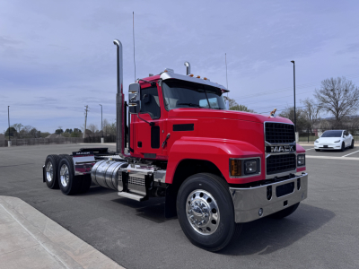 Mac PI64T truck in red side view showing exhaust stacks and chrome bumper.