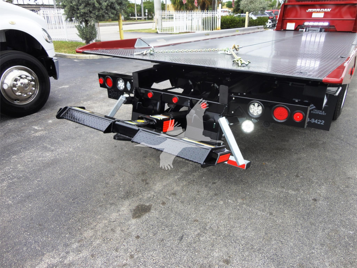 Truck bed with hydraulic rollback apparatus attached and rear lights visible on a 2022 Peterbilt 337 rollback truck.