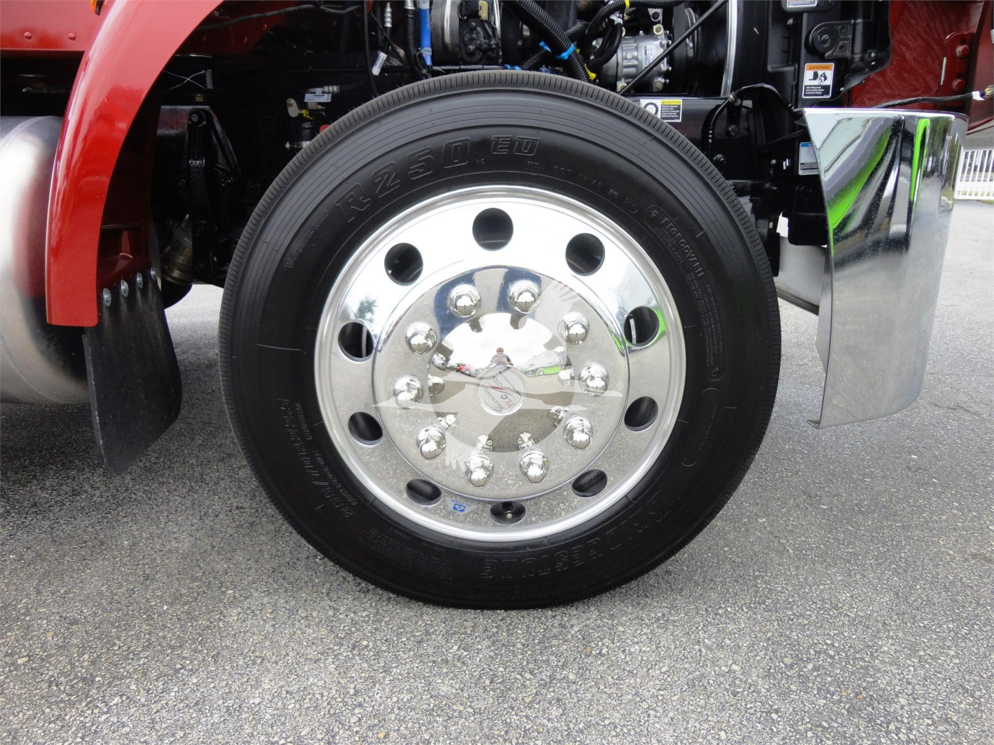 Peterbilt 337 front wheel and chrome hubcap with black tire, part of rollback truck showing front wheel area.
