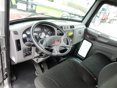 Truck cab interior of a 2022 Peterbilt 337 showing steering wheel, dashboard gauges, and driver seat.
