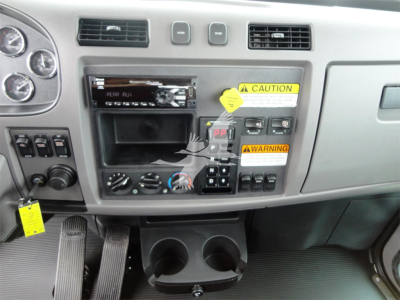 Peterbilt 337 dashboard/center console view with stereo, vents, controls, cup holders, and warning labels.