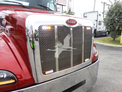 Peterbilt 337 front grille with chrome mesh, red cab, and amber marker lights.