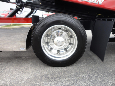 Peterbilt 337 rollback truck wheel and chrome hub showing tire and fender, with part of the bed and hydraulic setup.