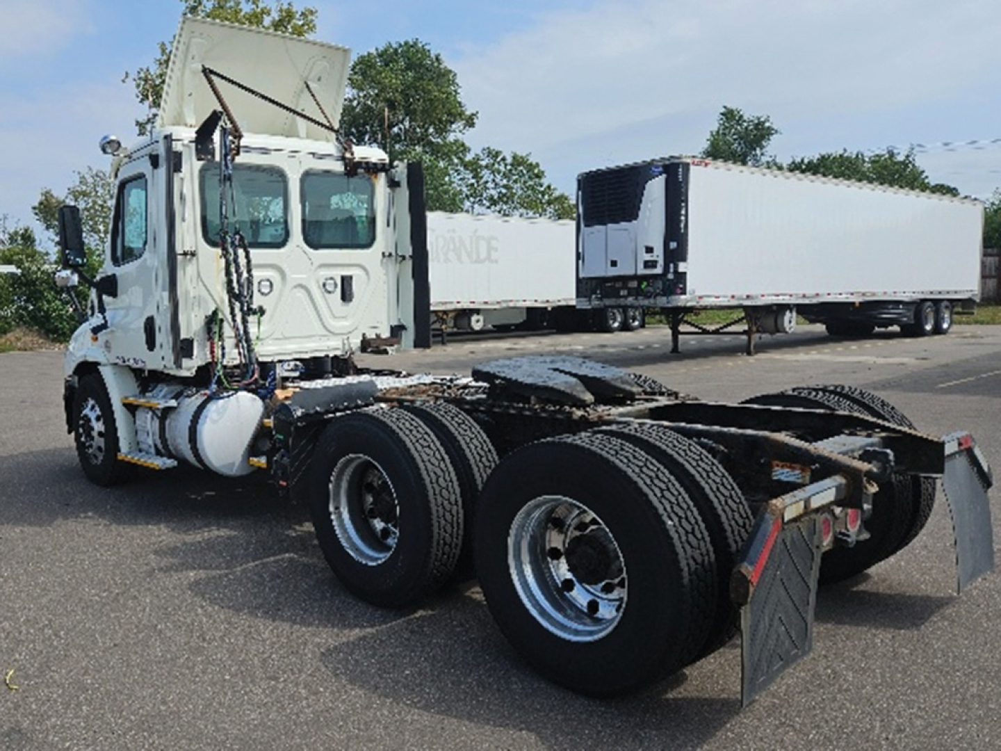 Freightliner Cascadia daycab chassis and rear axles showing dual rear wheel setup and fifth wheel area.