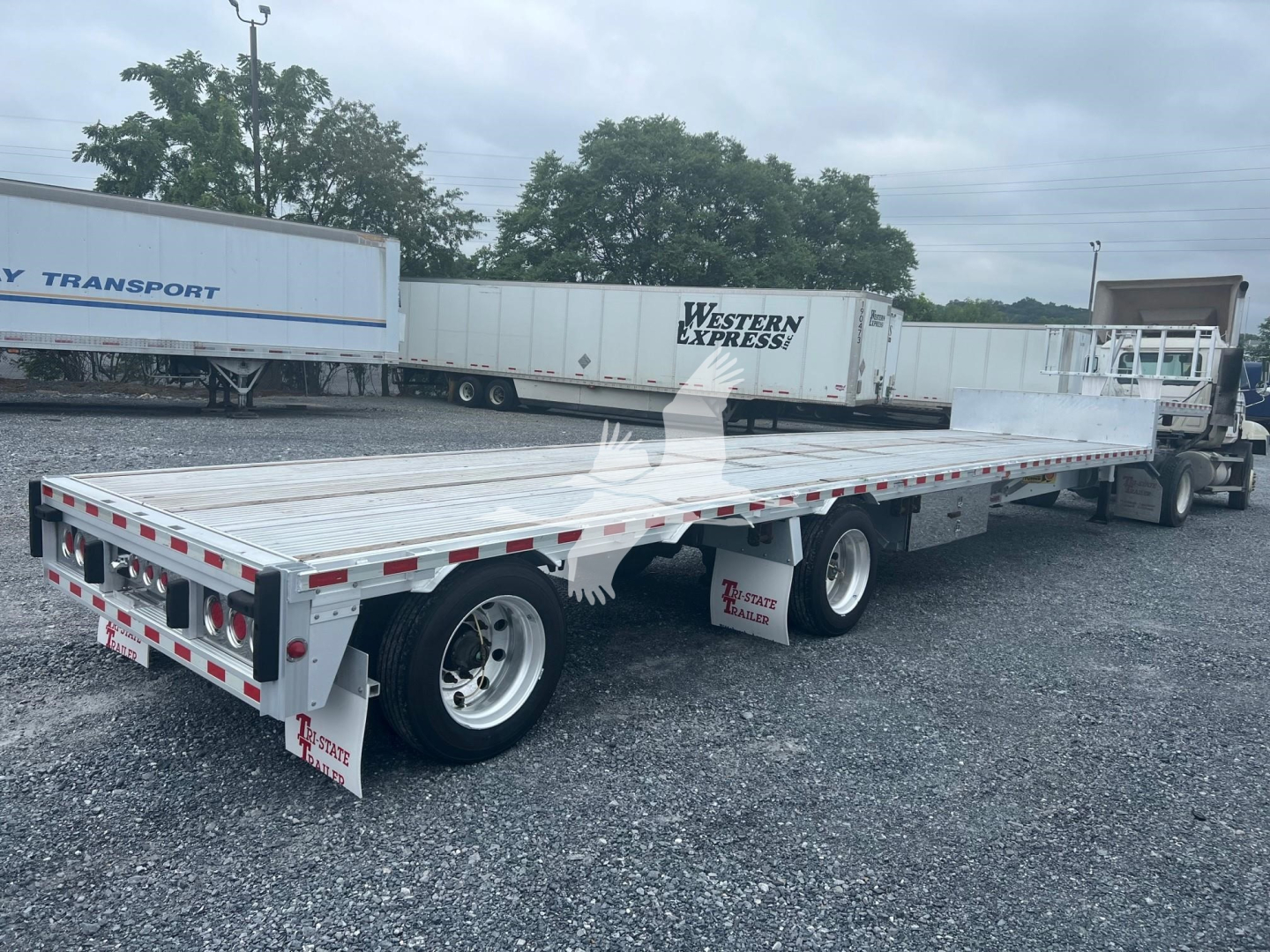 2018 Reitnouer Dropmiser flatbed trailer side and rear view showing aluminum deck and axles.