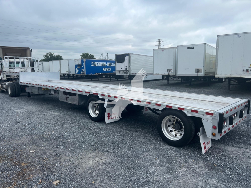 Dropdeck trailer showing extended flatbed with dual rear axles and aluminum decking