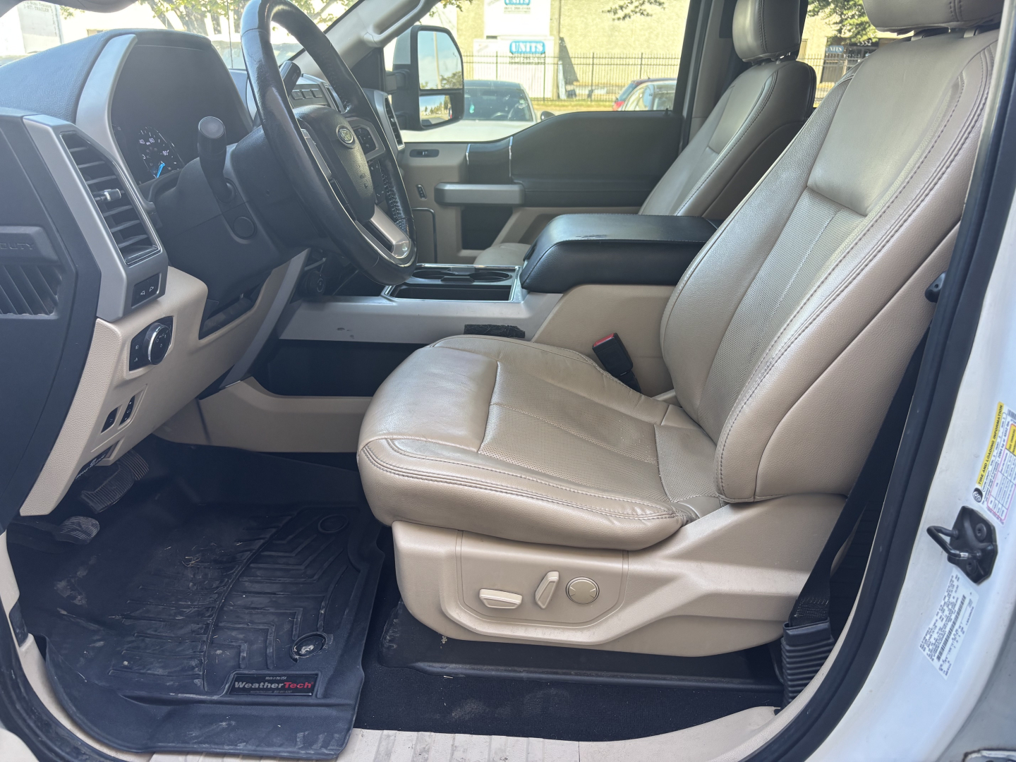 Ford F-350 cab and chassis interior showing front seats with beige leather and center console.