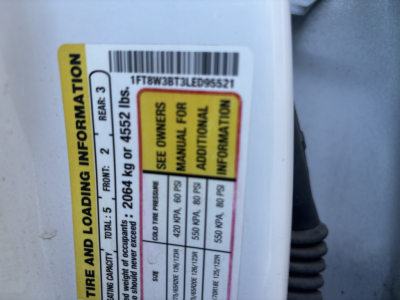 Ford F-Series cab and chassis VIN tag showing tire loading information and barcode sticker visible inside door jamb area