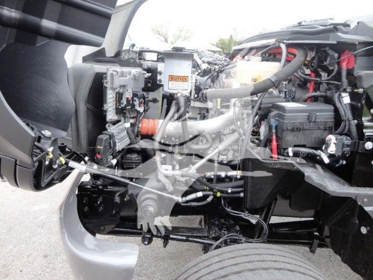 Trucks engine bay showing heavy equipment components and hoses in a 2023 International CV rollback truck.