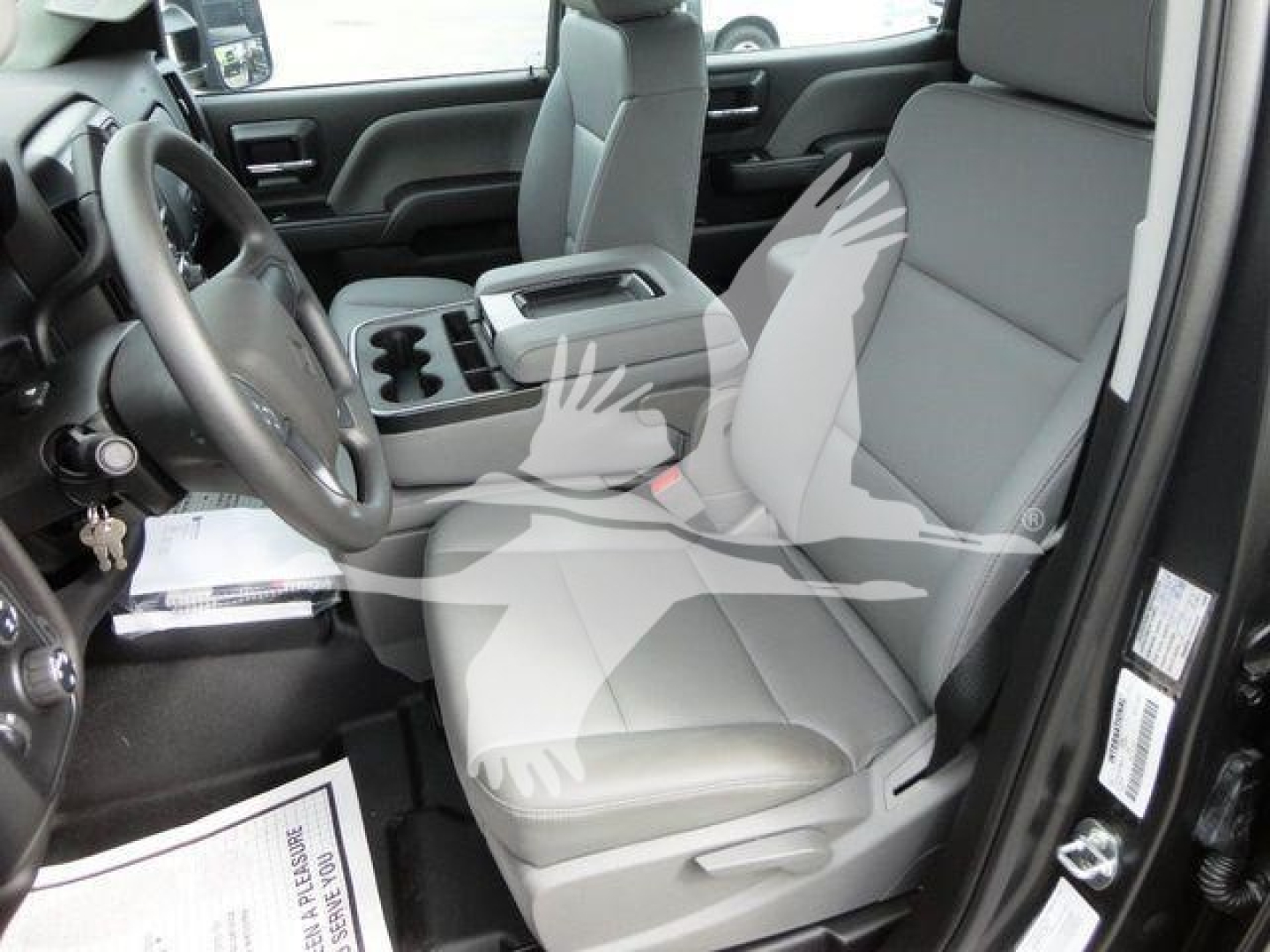 Interior of a 2023 International CV rollback truck cab showing driver seat, front passenger seat, center console, steering wheel, and door panel with visible seat upholstery.