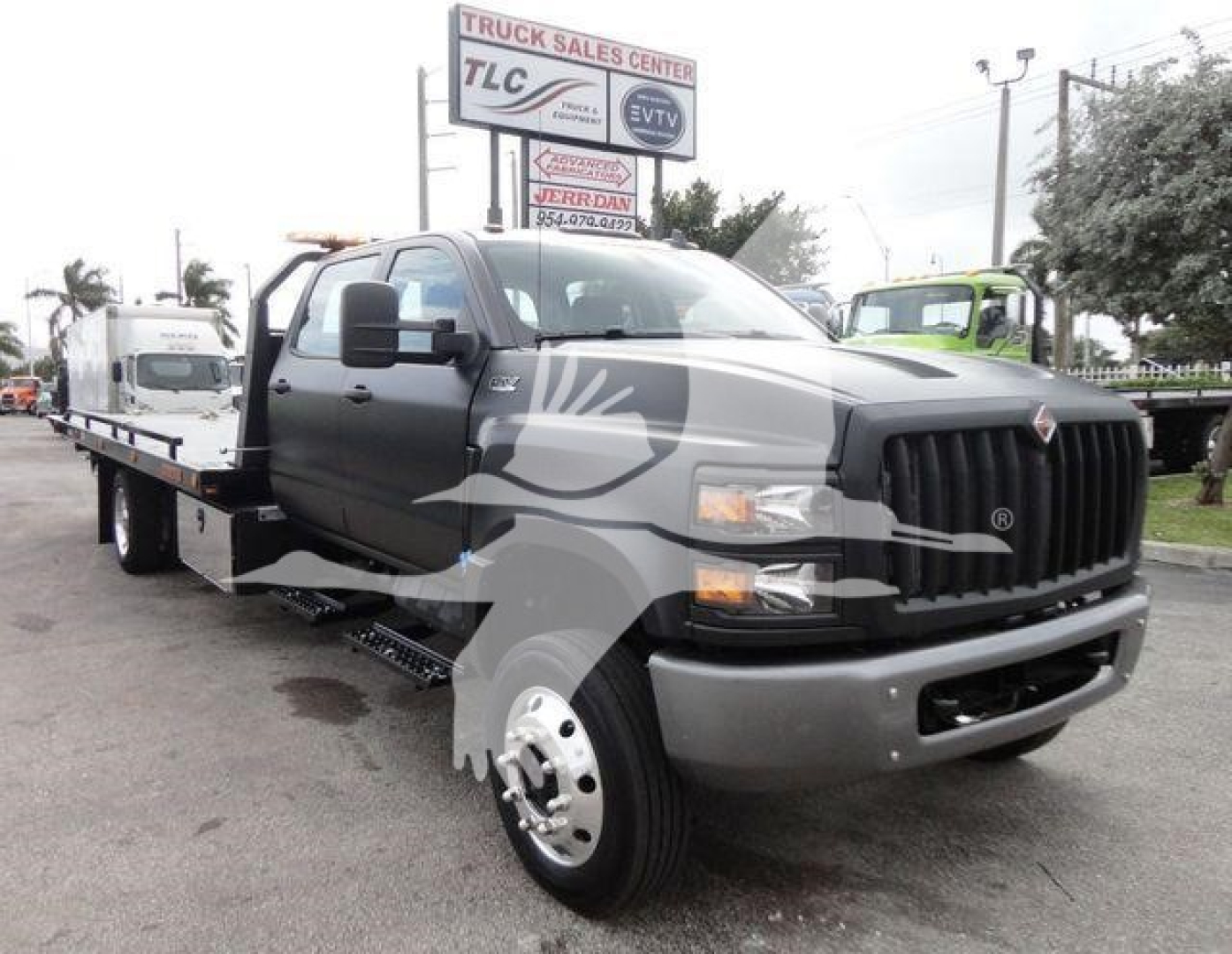 2023 International CV Rollback truck in serviceable condition with flatbed, showing front grille, dual headlights, and side mirrors.