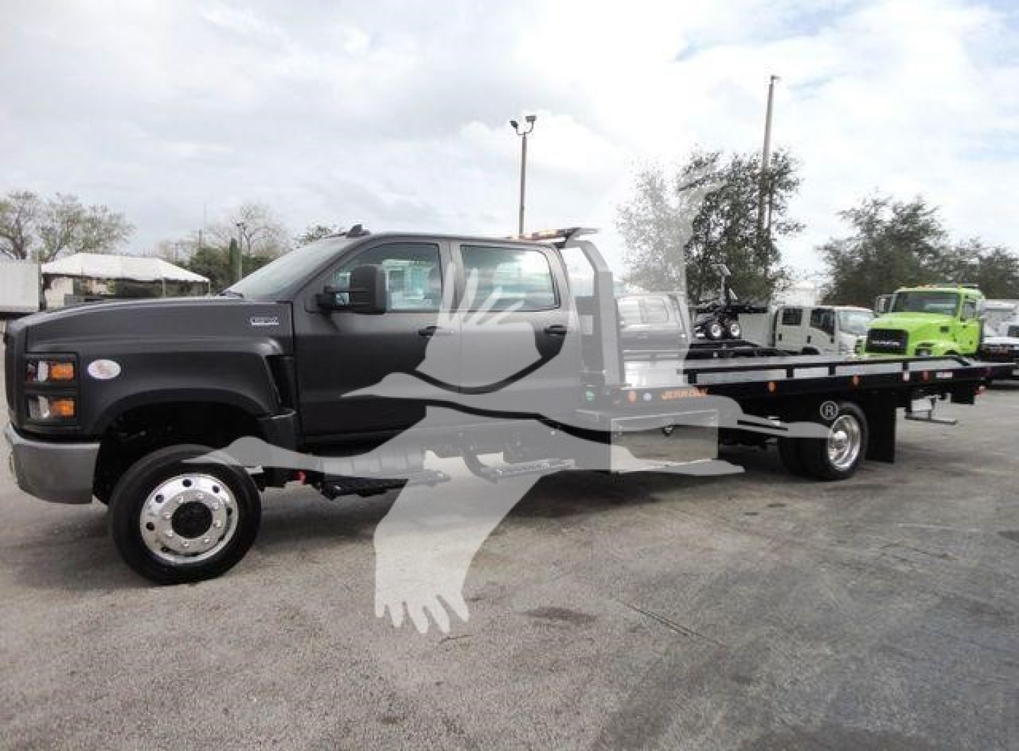 Truck cab with rollback flatbed showing International badge and heavy-duty tow truck chassis; side text not legible in image.