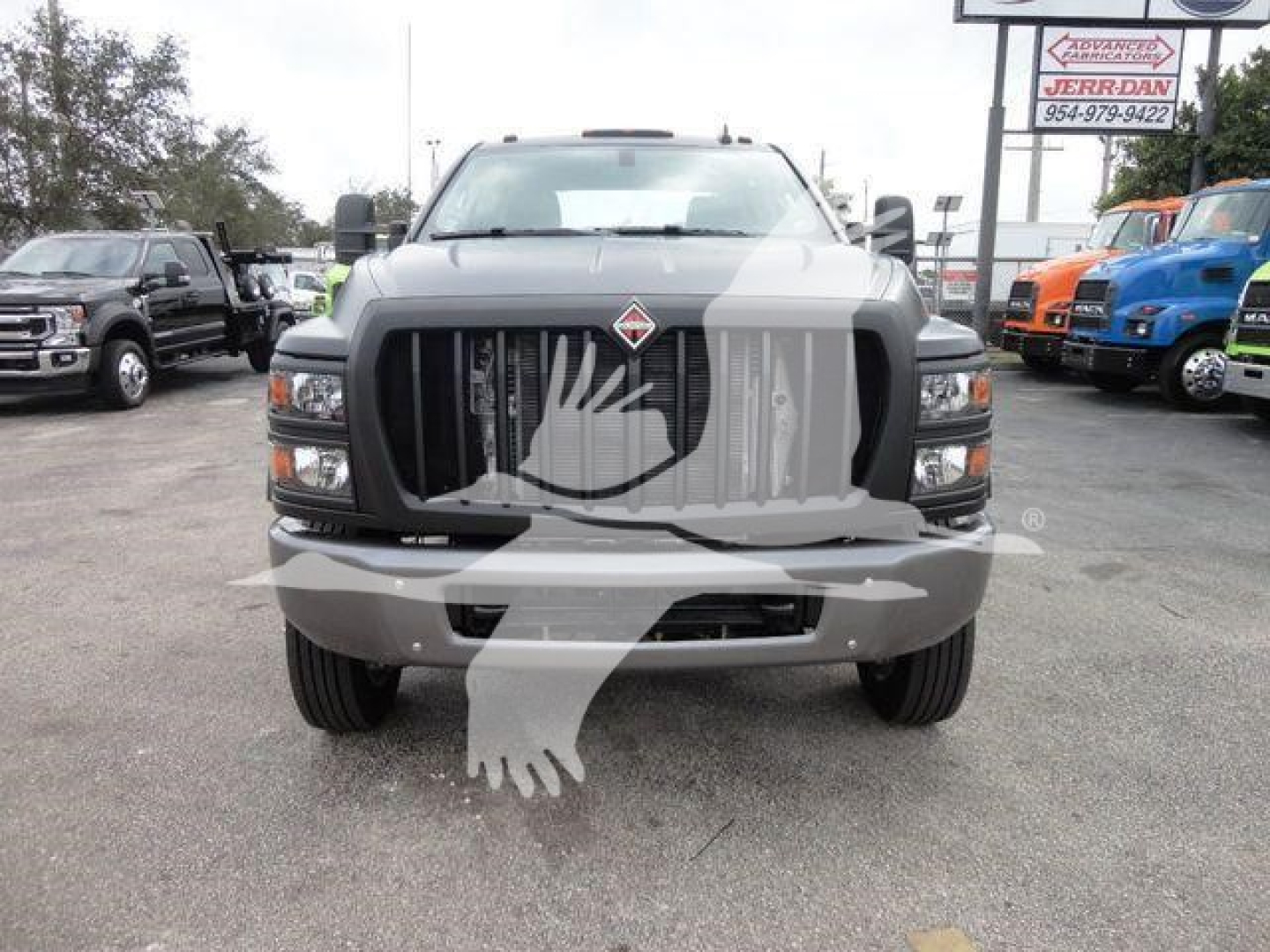 International CV truck front view showing grille, headlights, and bumper in a dealership lot.