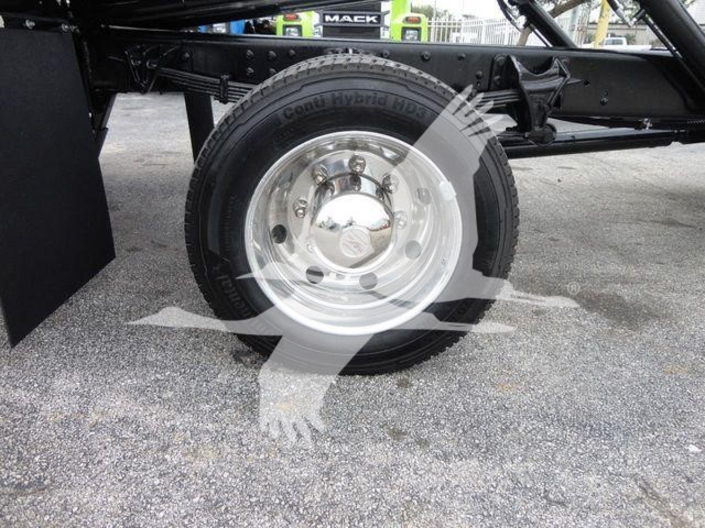 Truck chassis with front wheel and hub visible; tire reads Goodyear? and componentry underframe with rollback truck.