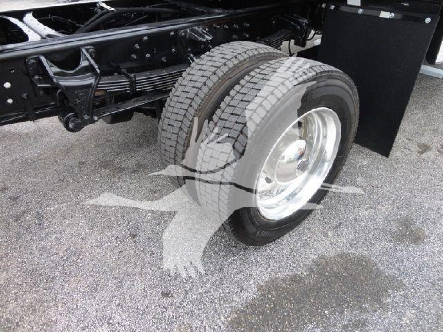 Truck undercarriage showing dual rear wheels, tire tread, and chassis frame of a new 2023 International CV rollback truck.