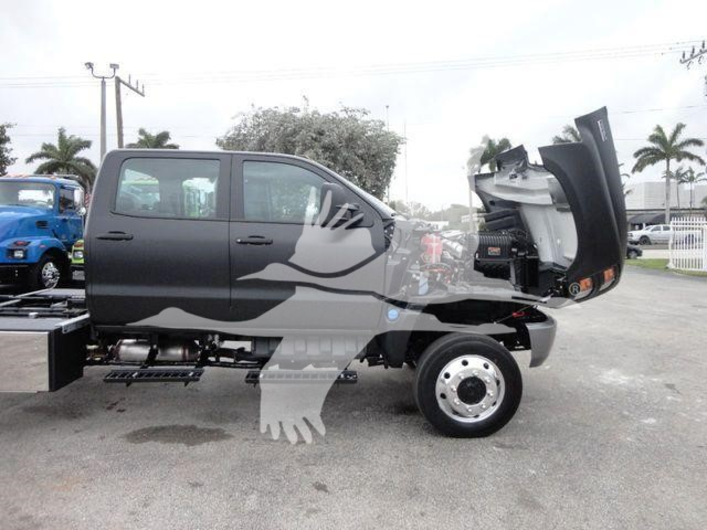Truck side view showing a 2023 International Cv rollback truck with the cab door open, gray exterior, and heavy-duty wheels.