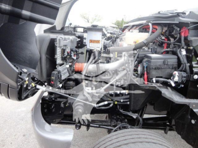 Trucks engine bay showing heavy equipment components and hoses in a 2023 International CV rollback truck.