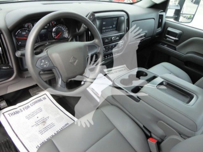 Interior of a 2023 International CV truck showing steering wheel, dashboard, center console, and front seats with light gray upholstery.