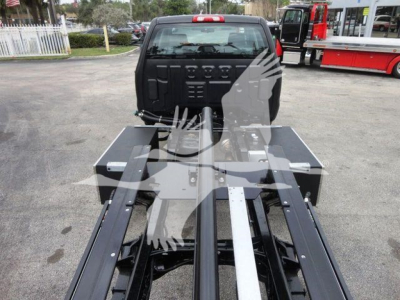 Truck cab with rollback chassis visible in bed area; no visible text on components.