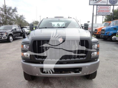 Front view of a gray 2023 International CV truck with large black grille, bumper, and dual side mirrors in a dealership lot.