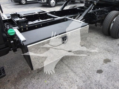 Truck chassis with large rectangular aluminum toolbox mounted, side view showing fuel tank cap and frame rails.