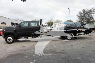 Truck with a rollback bed, black cab, side view showing long flatbed; no legible model text visible; image shows a two-axle truck with a ramp/bed setup.