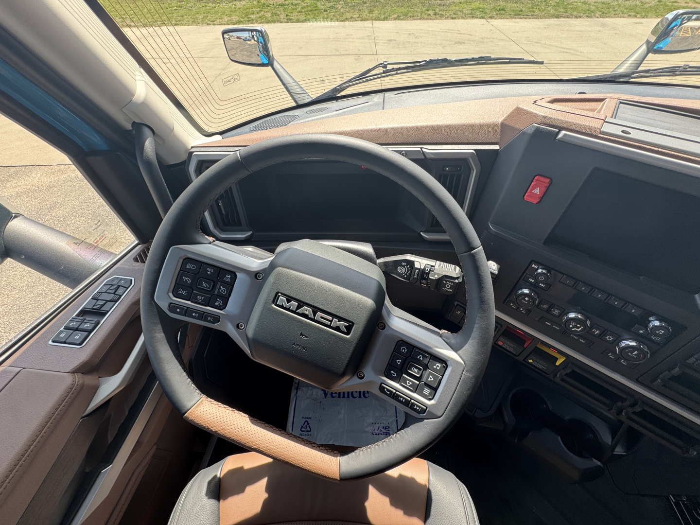 Dashboard and steering wheel of a Mack AN64T64 truck cab showing Mack logo on steering wheel and control panels.